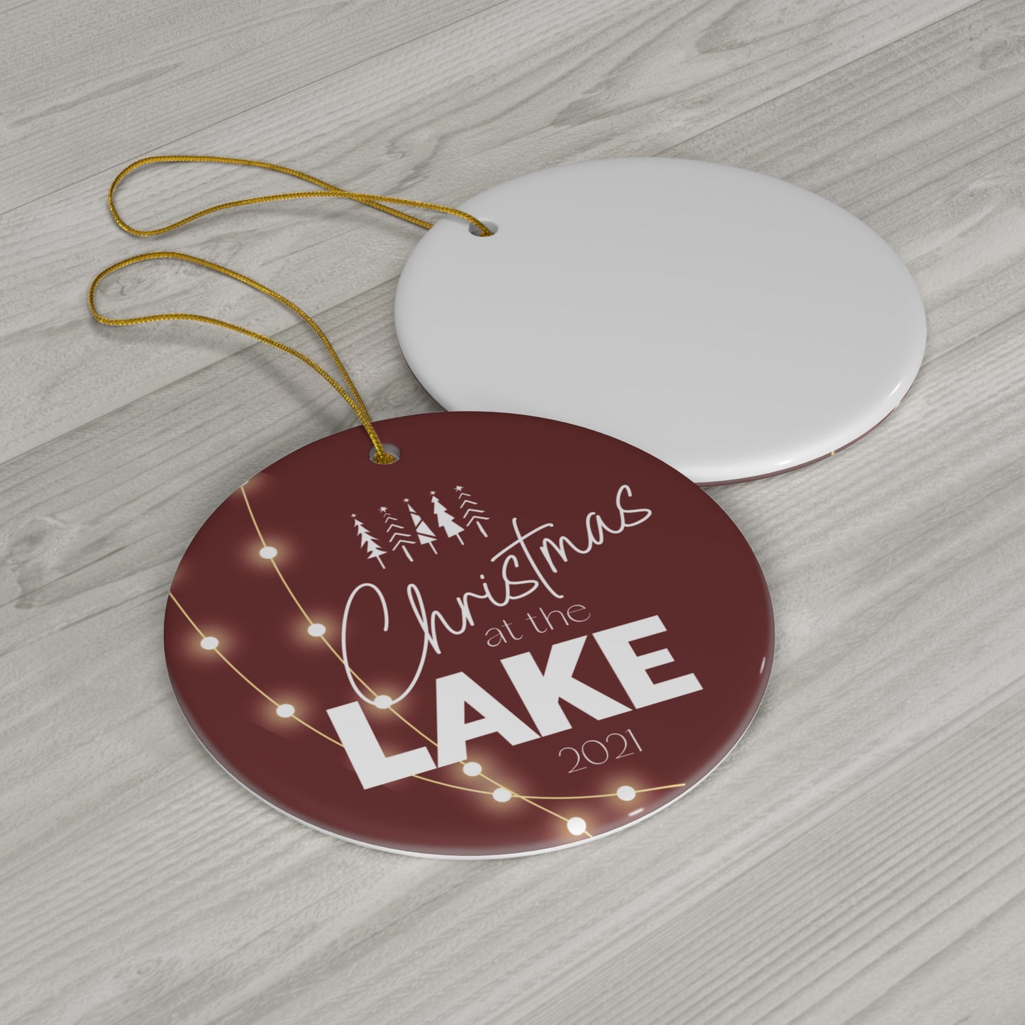 Christmas at the Lake 2021 Sparkling Lights Ceramic Ornament, elegant circle shaped tree ornament with a deep red colored background and white lettering