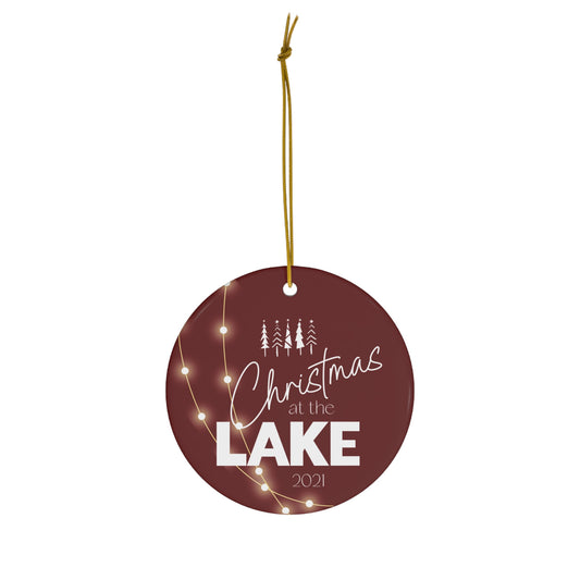 Christmas at the Lake 2021 Sparkling Lights Ceramic Ornament, elegant circle shaped tree ornament with a deep red colored background and white lettering