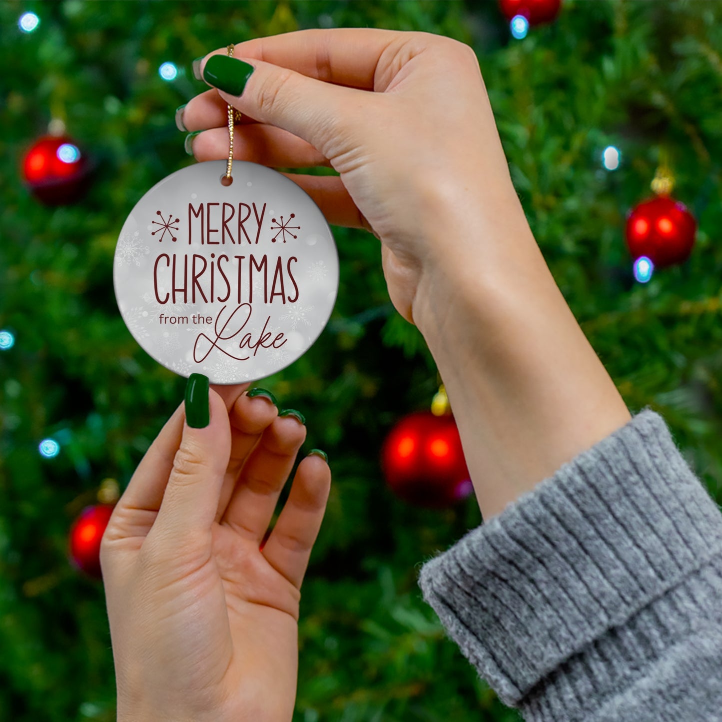 Merry Christmas from the Lake Ceramic Ornament, elegant circle shaped tree ornament with deep red colored farmhouse style lettering on a light grey snowflake background