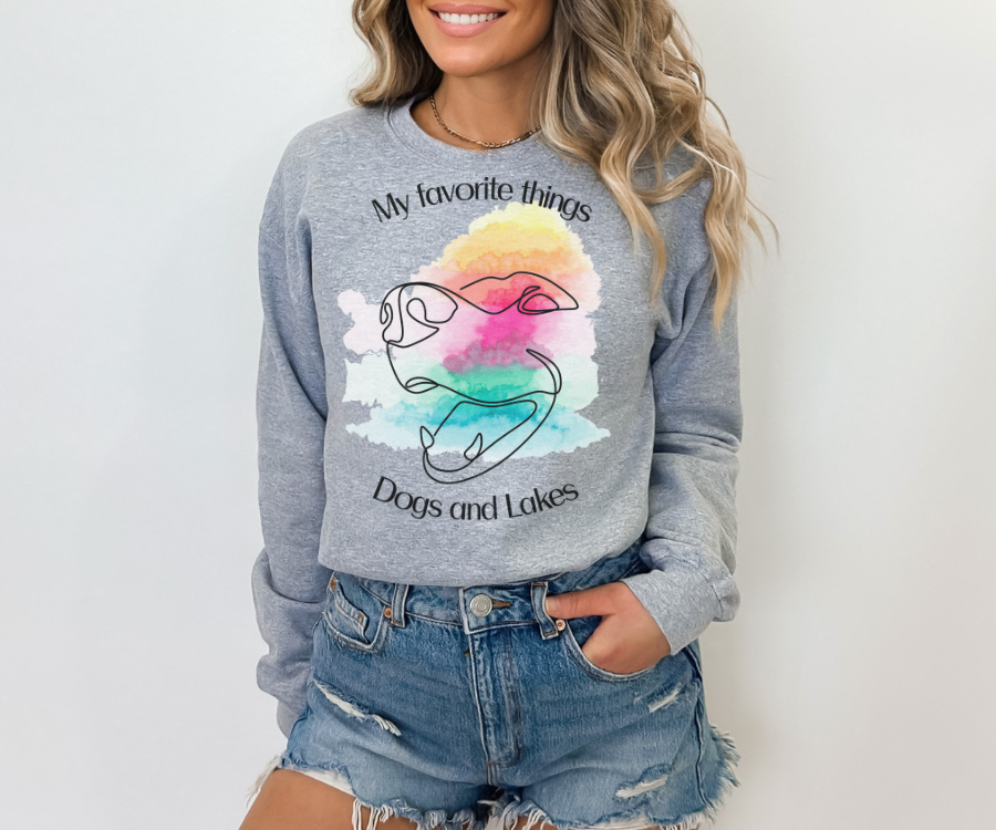 My Favorite Things ... Dogs and Lakes Unisex Sweatshirt, featuring a line drawing of a cute dog face on a multi-color watercolor back drop.